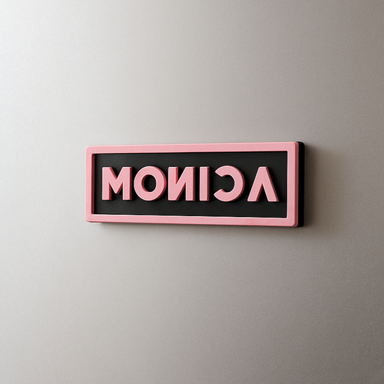 Blackpink custom magnet with the name 'MONICA' in pink letters on a gray fridge.