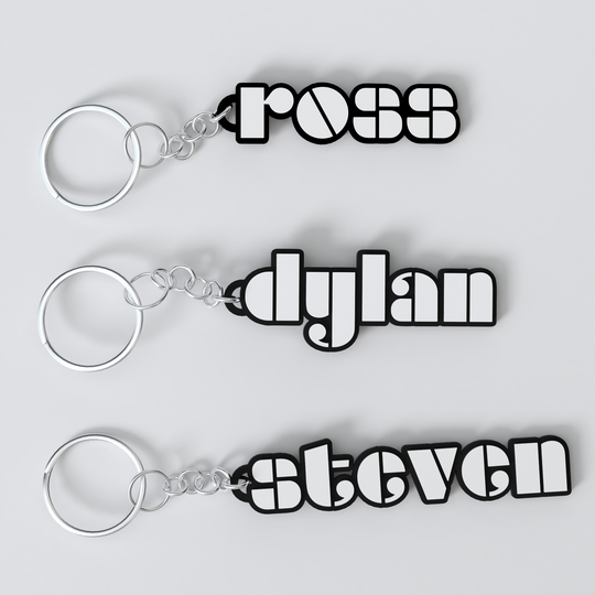 Three custom The Doors keychains with the names 'ross', 'dylan', and 'steven' printed on them, each keychain is black with a white outline of the name and a silver keyring.