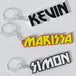 Custom KISS keychains with the names Kevin, Marissa, and Simon printed in bold lettering on a white background.