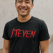 Man wearing a custom Slayer black t-shirt with red text 'STEVEN' against a neutral background