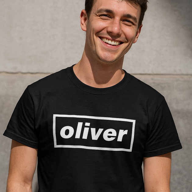 Man wearing a custom black t-shirt with 'oliver' Oasis logo against a gray wall