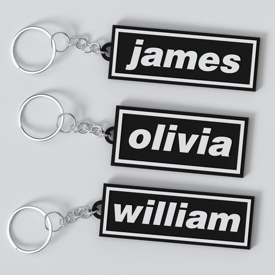 Three custom Oasis keychains with names 'James', 'Olivia', and 'William' displayed on a white background.