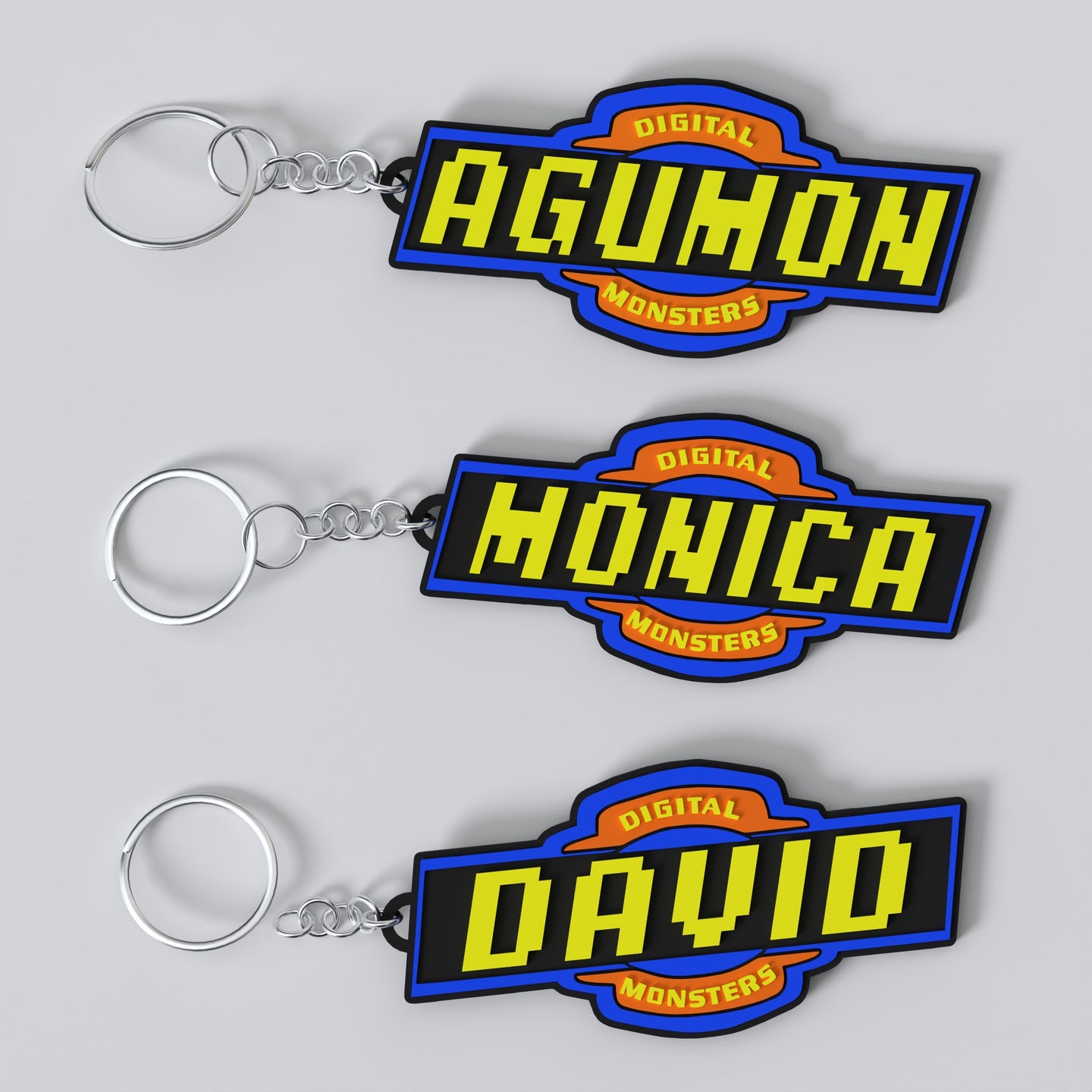 Custom anime-themed DIGIMON keychains with personalized engravings. One keychain reads 'AGUMON' with a blue and yellow font on a black background, and the other reads 'DAVID' with a similar color scheme.