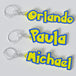 Three Pokemon custom keychains with personalized text. The keychains are in blue, yellow, and white colors with the text 'ORLANDO', 'PAULA', and 'MICHAEL' respectively.
